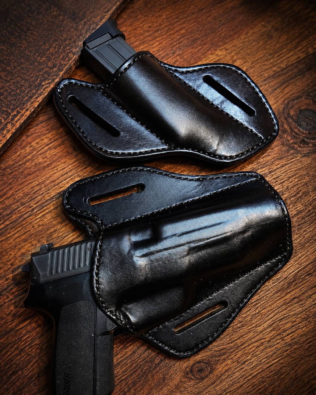Pair of black leather pistol holsters.