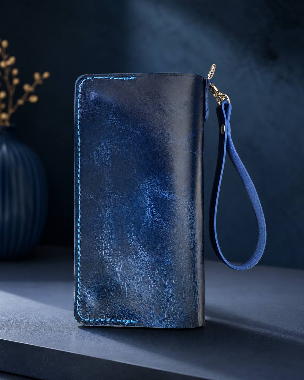 Blue leather wallet with wrist strap.