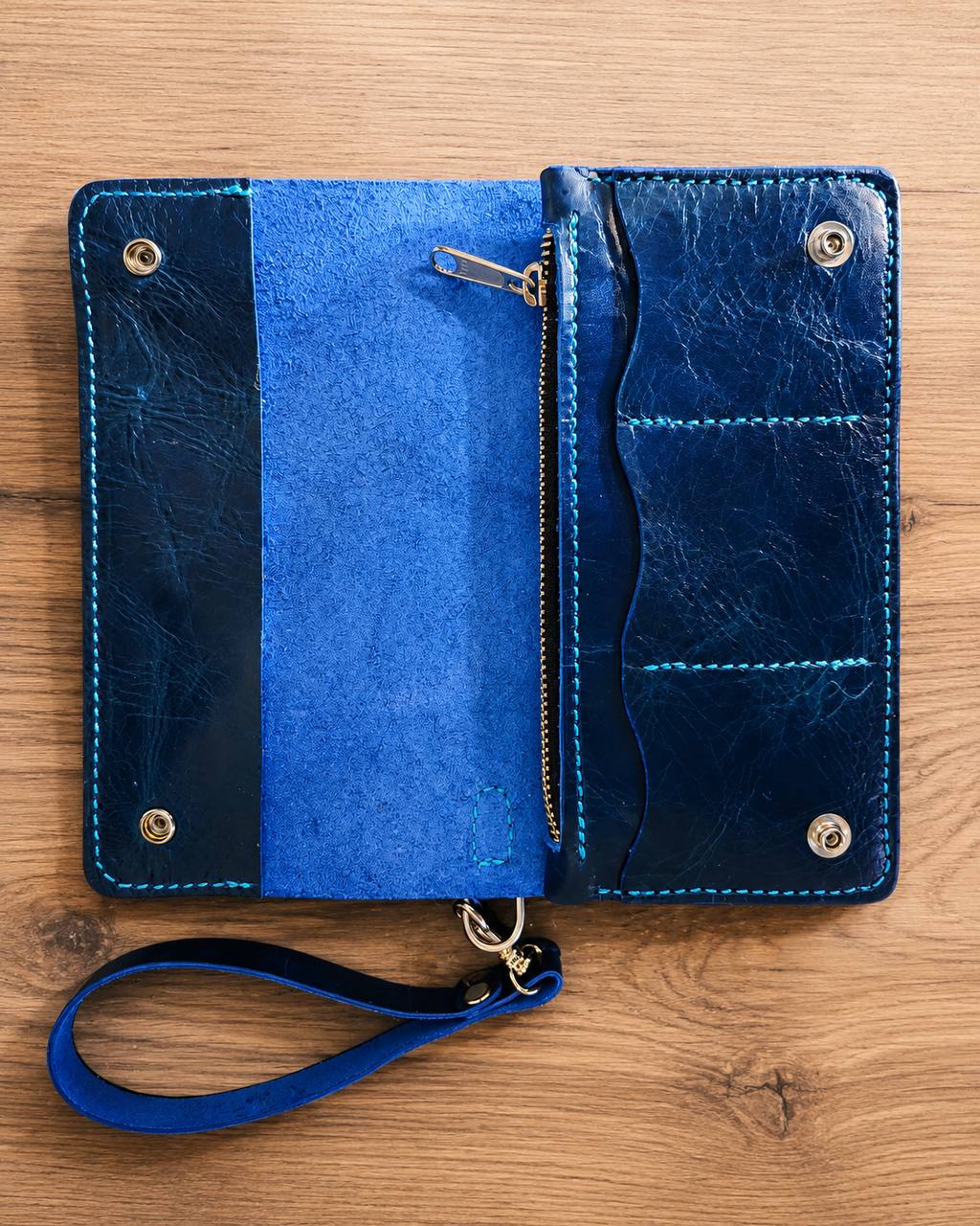 Open blue leather wallet with zipper and card pockets.