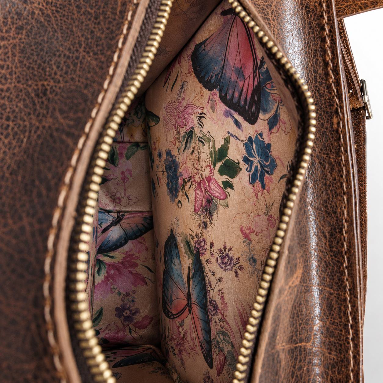 Brown leather bag with patterned interior lining.