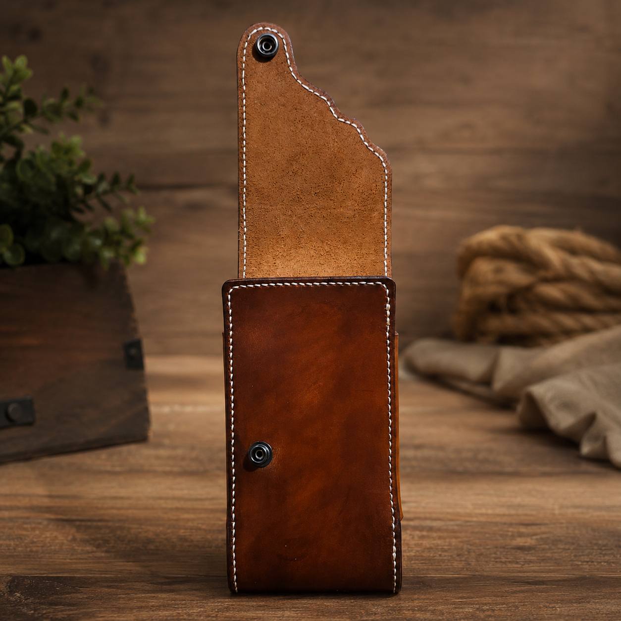 Brown leather phone case with strap.