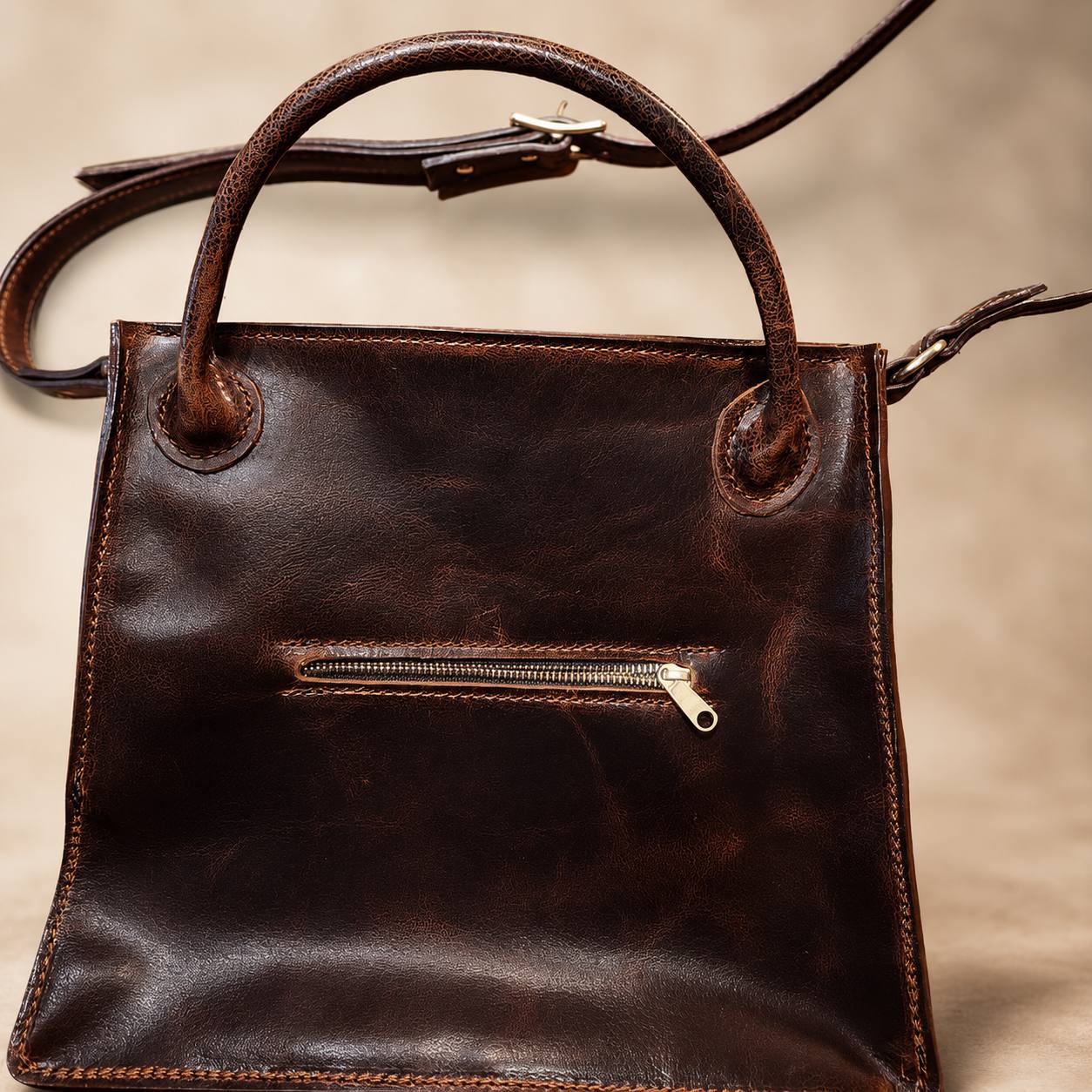 Brown leather handbag with zipper pocket.