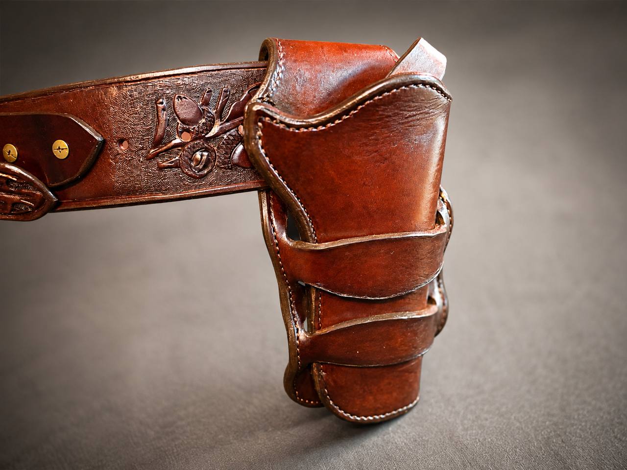 Close view of tooled leather holster and belt.