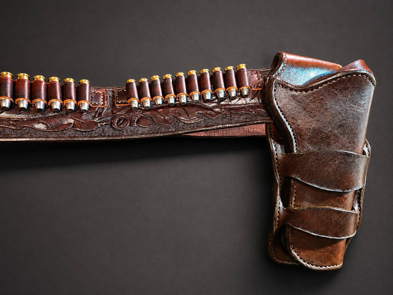 Tooled leather holster belt with shell loops.