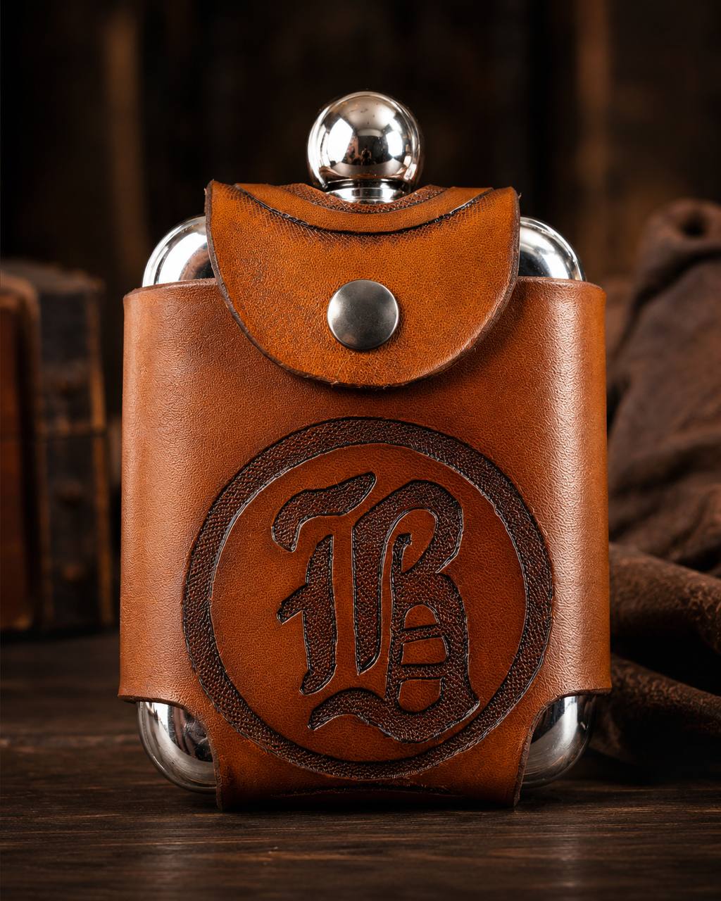 Leather flask holder with monogram tooling.