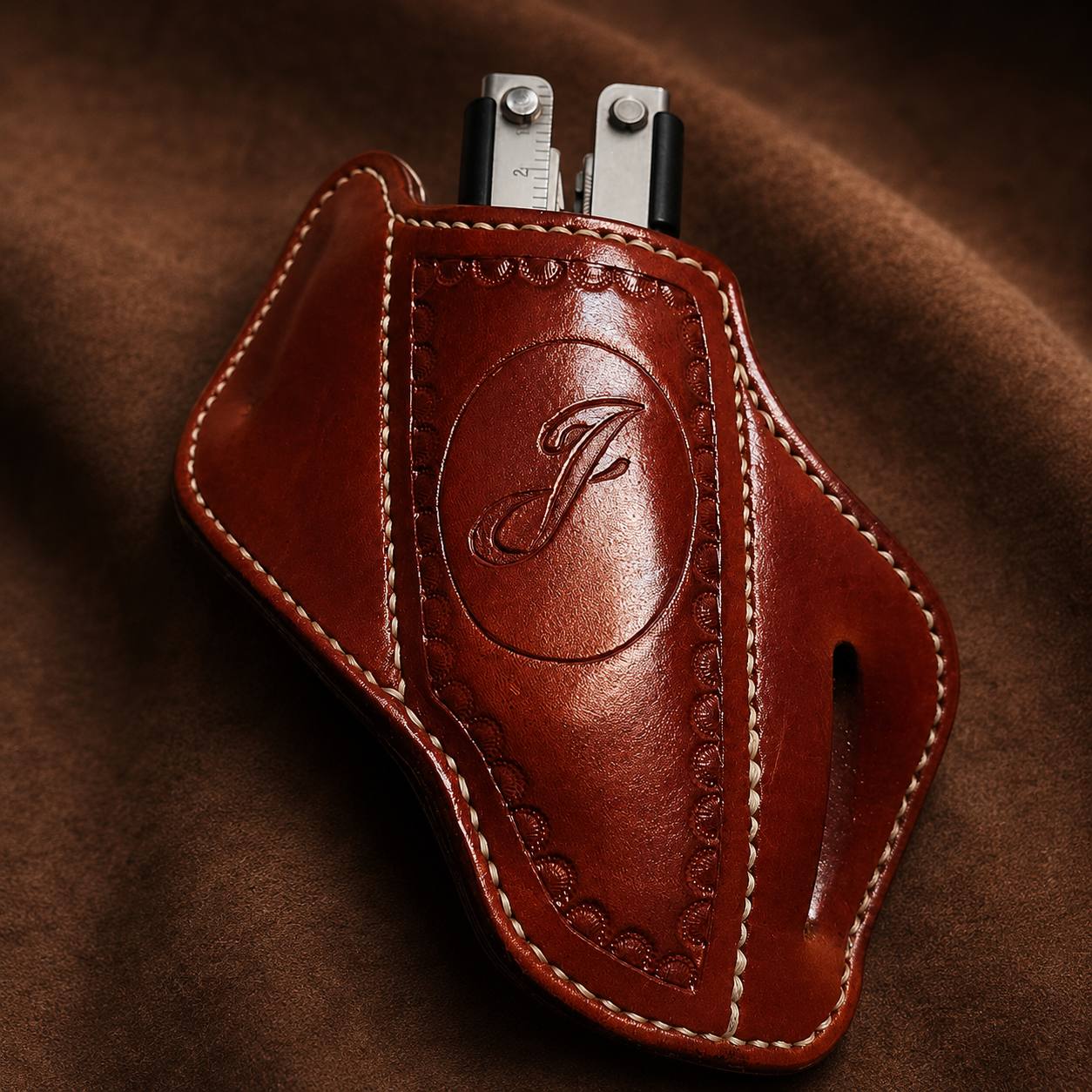Brown leather multitool sheath with monogram.