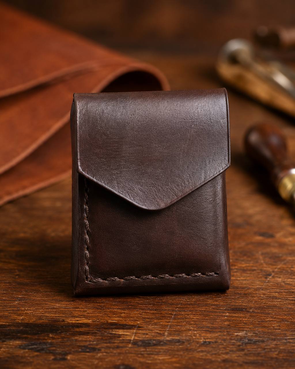 Plain dark brown leather pouch with flap closure.