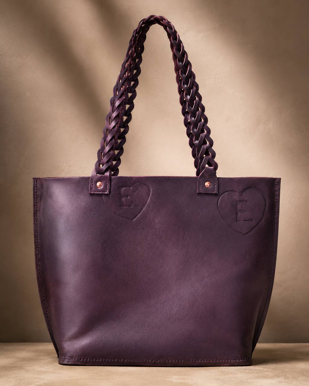 Purple leather tote with braided handles.