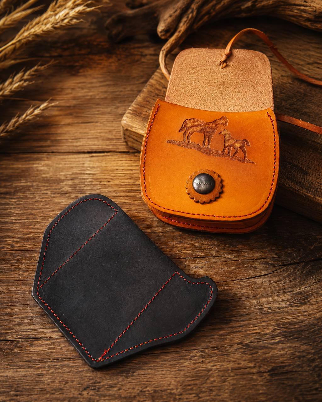 Small leather purse and black leather wallet on a wood table.