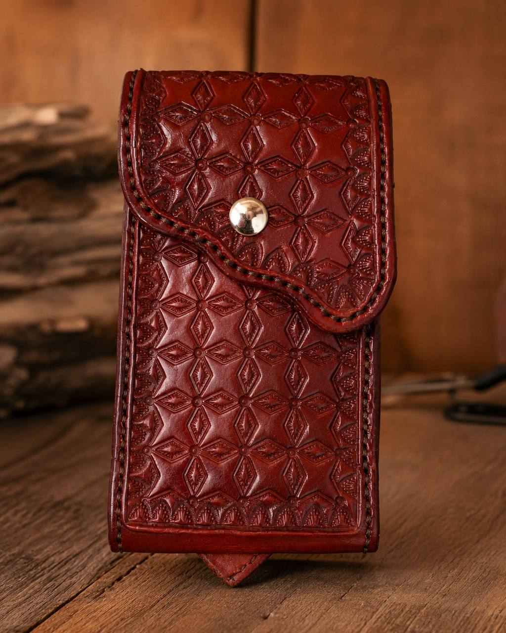 Red tooled leather phone pouch with snap closure.
