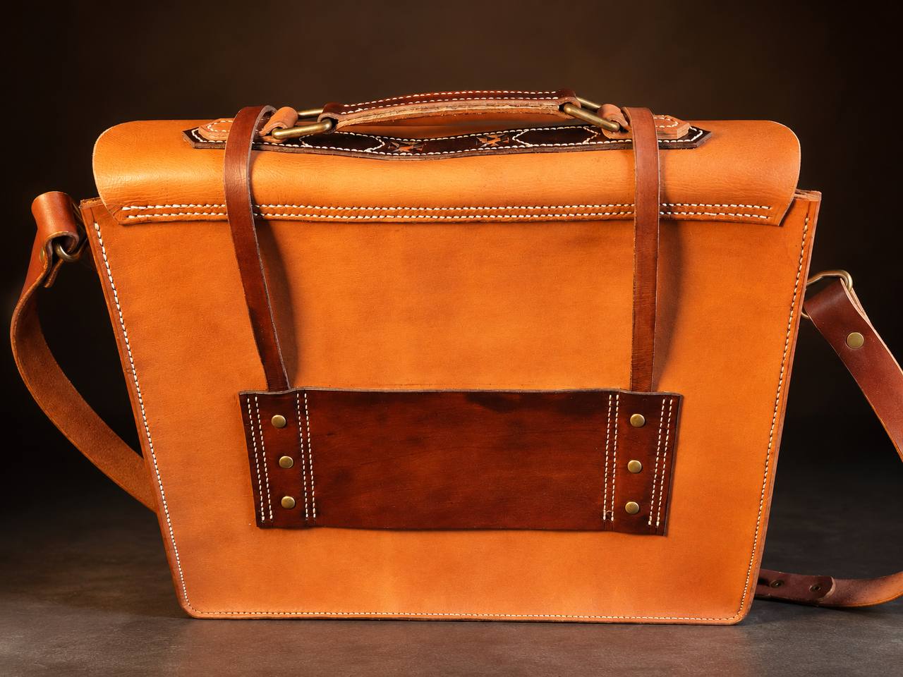 Back view of a tan western leather satchel.