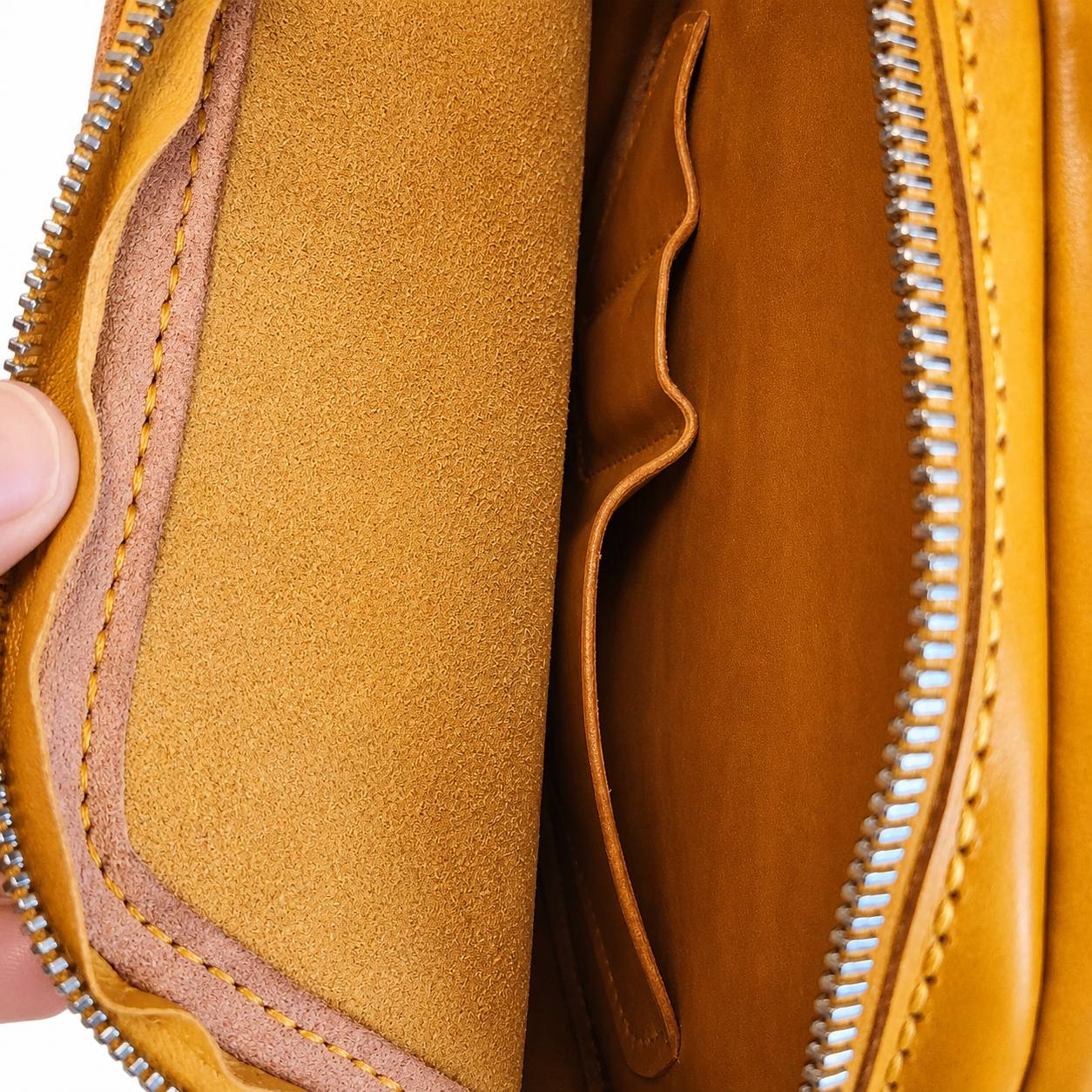 Interior of yellow leather bag with zipper and pockets.